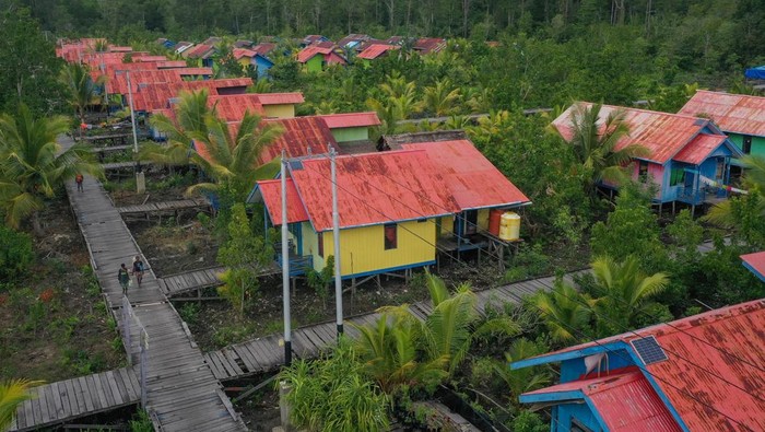 Potret Kampung Pelangi Kaye, Program Relokasi Suku Asmat Papua Warga berjalan di atas jalan panggung Kampung Pelangi Kaye, Distrik Agats, Kabupaten Asmat, Papua Selatan, Jumat (2/6/2023). Kampung tersebut telah direvitalisasi oleh Presiden Joko Widodo sejak 2018 dan menjadi lokasi program relokasi suku Asmat dari pedalaman ke daerah yang lebih mudah dijangkau. ANTARA FOTO/Aditya Pradana Putra/nz.
