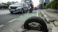 Pengendara melintas di samping gorong-gorong yang bolong karena penutupnya rusak di Jalan Cut Mutia, Kota Bekasi, Jawa Barat, Senin (5/6/2023).