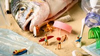 Menggunakan ikan segar dan plastik kemasannya, Peter menghadirkan musim panas di tepi pantai. Ada pengunjung yang sedang berselancar hingga bersandar di atas ikan. Foto: Bored Panda