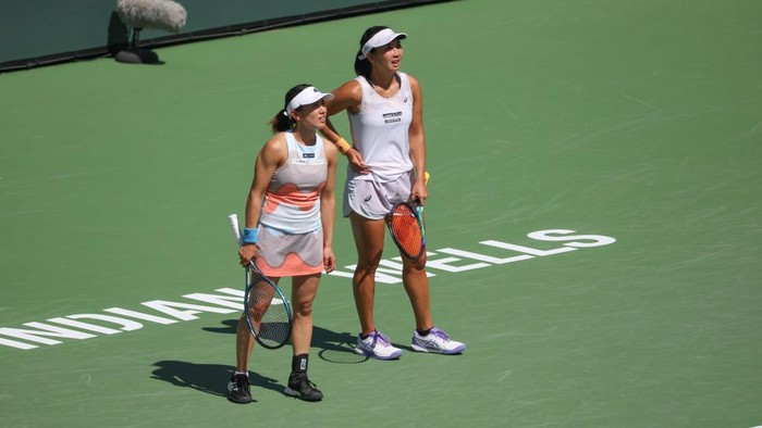INDIAN WELLS, CA - MARCH 17: Miyu Kato (JPN) and Aldila Sutjiadi (INA) look across the court to their doubles opponents during the BNP Paribas Open on March 17, 2023 at the Indian Wells Tennis Garden in Indian Wells, CA. (Photo by George Walker/Icon Sportswire via Getty Images)