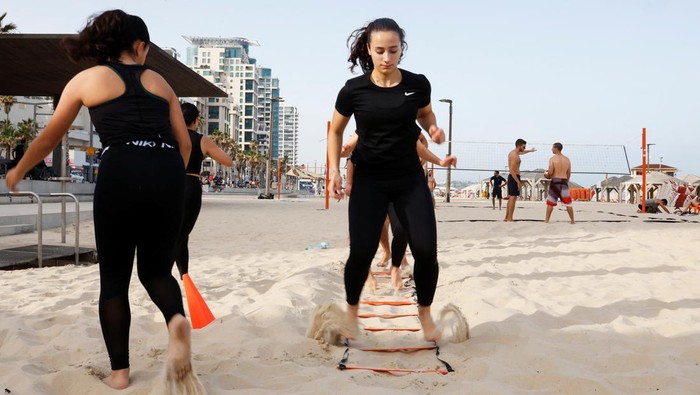 Olahraga di Pantai, Cara Warga Palestina Melepas Penat dari Kota Members of a fitness group of Palestinians from East Jerusalem work out on a beach in Tel Aviv, Israel May 26, 2023. REUTERS/Ammar Awad
