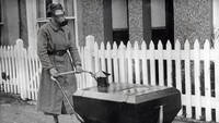 Stroller Tahan Gas: Seorang wanita menguji kereta bayi yang dirancang agar tahan terhadap serangan gas di Hextable, Inggris pada tahun 1938, tidak lama sebelum pecahnya Perang Dunia II. Foto: Wikimedia Commons