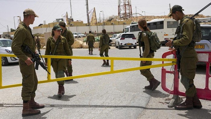 Israeli soldiers secure a gate leading to a military base following a deadly shootout in southern Israel along the Egyptian border, Saturday, June 3, 2023. (AP Photo/Tsafrir Abayov)