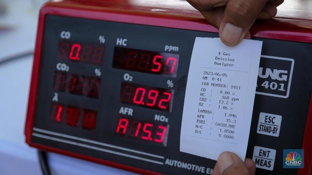 Petugas melakukan uji emisi kendaraan bermotor saat acara Uji Emisi Akbar (UEA) di Parkir Utara Taman Marga Satwa Ragunan, Jakarta, Senin (5/6/2023). (CNBC Indonesia/Faisal Rahman)
