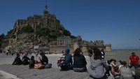 Pulau Mont-Saint-Michel, salah satu destinasi wisata paling populer di luar Paris, menarik 2,8 juta pengunjung tahun lalu, termasuk 1,3 juta orang untuk mendatangi biara di sana. (Artur Widak/Anadolu Agency/Getty Images)