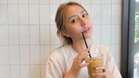 Saat bersantai di kafe, ia juga memilih untuk memesan es kopi yang menyegarkan. Duduk di dekat jendela menjadi spot favoritnya sambil minum kopi. Foto: Instagram/clairineclay