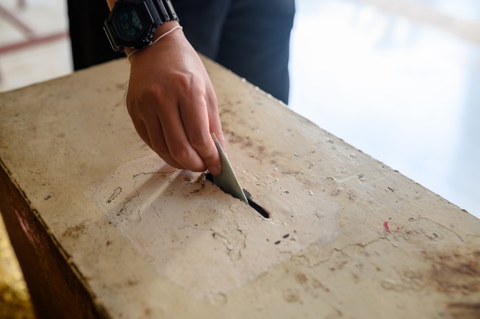 Image of Man hand donating money into charity box.