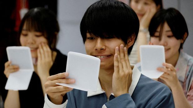 Students learn how to practice facial muscles with mirrors at a smile training course at Sokei Art School in Tokyo, Japan, May 30, 2023. REUTERS/Kim Kyung-Hoon     TPX IMAGES OF THE DAY