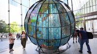 Sejumlah pengunjung melihat sebuah patung Earth Poetica atau bola bumi raksasa di loby gedung 3 World Trade Center di New York City, Senin (5/6/2023).