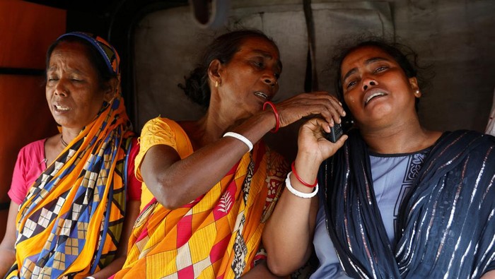 Nestapa Keluarga Korban Kereta Maut di India Relatives of train collision victims react as they sit in an autorickshaw outside a temporary mortuary created in a business park, following the train collision in Balasore district in the eastern state of Odisha, India, June 4, 2023. REUTERS/Adnan Abidi