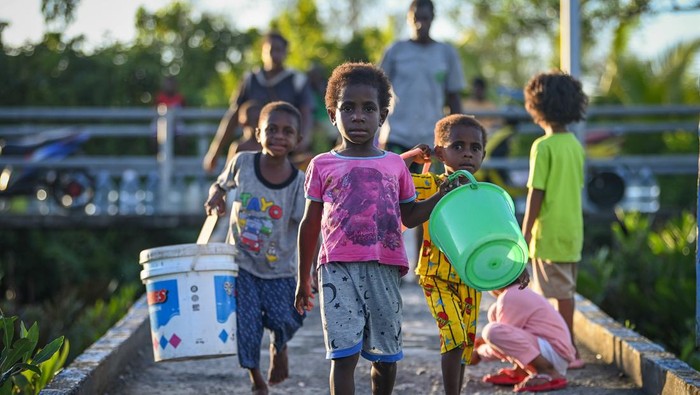 Sejumlah anak membawa ember untuk mengambil air bersih dari reservoir penampung air hujan fasilitas dari pemerintah di Distrik Agats, Kabupaten Asmat, Papua Selatan, Jumat (2/6/2023). Kementerian Pekerjaan Umum dan Perumahan Rakyat (PUPR) telah membangun tiga buah reservoir penampung air hujan berkapasitas masing-masing 1.000 meter kubik untuk memenuhi kebutuhan air bersih bagi masyarakat Agats yang kotanya berdiri di atas tanah rawa. ANTARA FOTO/Aditya Pradana Putra/nz.