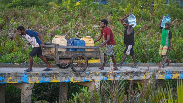 Sejumlah anak membawa ember untuk mengambil air bersih dari reservoir penampung air hujan fasilitas dari pemerintah di Distrik Agats, Kabupaten Asmat, Papua Selatan, Jumat (2/6/2023). Kementerian Pekerjaan Umum dan Perumahan Rakyat (PUPR) telah membangun tiga buah reservoir penampung air hujan berkapasitas masing-masing 1.000 meter kubik untuk memenuhi kebutuhan air bersih bagi masyarakat Agats yang kotanya berdiri di atas tanah rawa. ANTARA FOTO/Aditya Pradana Putra/nz.