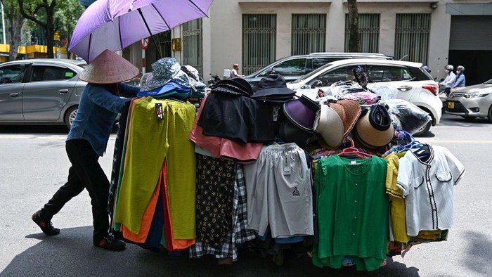 A street vendor pushes a cart of clothes in Hanoi on June 1, 2023. Thousands of street vendors, largely women, in Vietnam's capital have had no choice but to work through a series of heatwaves that have struck the north of the country in recent weeks. (Photo by Nhac NGUYEN / AFP) / To go with 'VIETNAM-CLIMATE-ENVIRONMENT-ECONOMY,SCENE' by Tran Thi Minh Ha (Photo by NHAC NGUYEN/AFP via Getty Images)