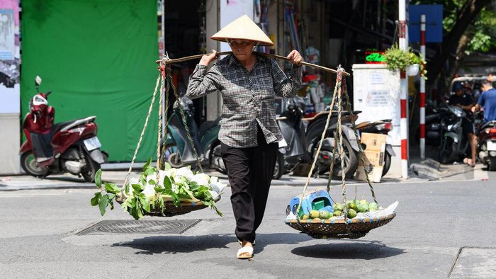 A street vendor pushes a cart of clothes in Hanoi on June 1, 2023. Thousands of street vendors, largely women, in Vietnam's capital have had no choice but to work through a series of heatwaves that have struck the north of the country in recent weeks. (Photo by Nhac NGUYEN / AFP) / To go with 'VIETNAM-CLIMATE-ENVIRONMENT-ECONOMY,SCENE' by Tran Thi Minh Ha (Photo by NHAC NGUYEN/AFP via Getty Images)