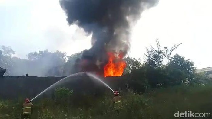 Petugas berusaha memdamkan api di gudang home industry timba plastik di Jombang