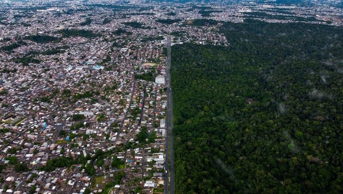Aerial view of the Adolpho Ducke Forest Reserve, part of Amazonia rainforest, side by side with houses of the neighborhood Cidade de Deus (City Of God) located in the east zone of Manaus, Amazonas state, Brazil on June 5, 2023, during the World Environment Day. (Photo by MICHAEL DANTAS / AFP) (Photo by MICHAEL DANTAS/AFP via Getty Images)