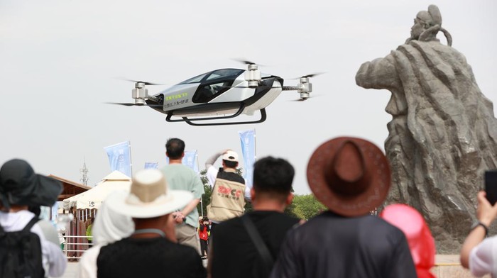 ZHONGWEI, CHINA - JUNE 05: Tourists watch a XPeng Voyager X2 Flying Car at Shapotou scenic spot on June 5, 2023 in Zhongwei, Ningxia Hui Autonomous Region of China. (Photo by Yu Jing/China News Service/VCG via Getty Images)
