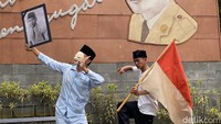 Ada dua orang penari, satu penari mengenakan pakaian tidur, kopiah berwarna hitam, topeng berwarna putih dan membawa foto Presiden Soekarno muda. (Foto: Wisma Putra/detikJabar)