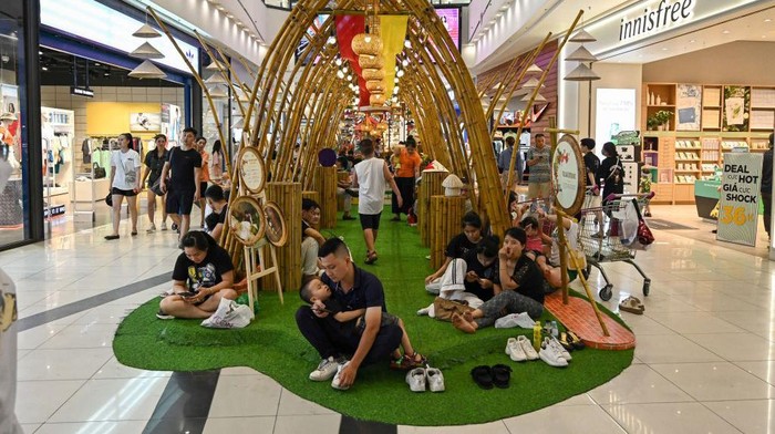 Vietnam Panas Banget, Warga Sampai Ngadem di Mal People gather outside a room in a shopping mall set aside for those wanting to escape high outdoor temperatures in Hanoi on June 3, 2023. Parts of northern Vietnam experienced power shortages June 3 with rolling outages as the grid struggled to cope with increased demand for cooling as the mercury soared. (Photo by Nhac NGUYEN / AFP) (Photo by NHAC NGUYEN/AFP via Getty Images)