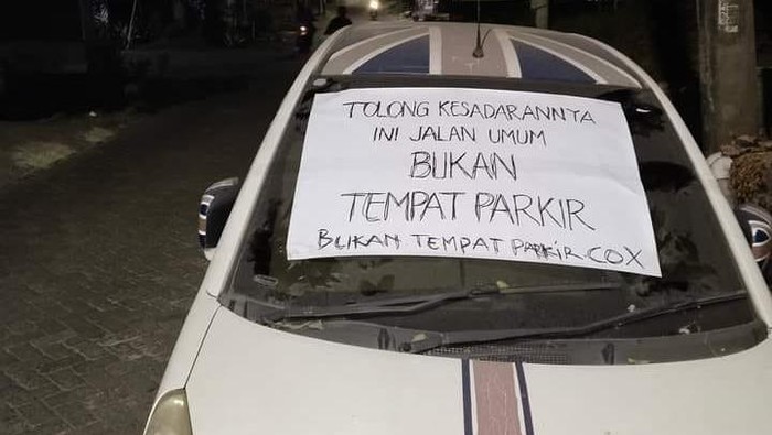 Warga pasang poster berisi protes di Mobil yang terparkir selama berbulan-bulan di Gresik