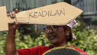 Mereka menggelar aksi sambil membawa pedang yang terbuat dari kertas dan tampah beras sebagai tamengnya.
