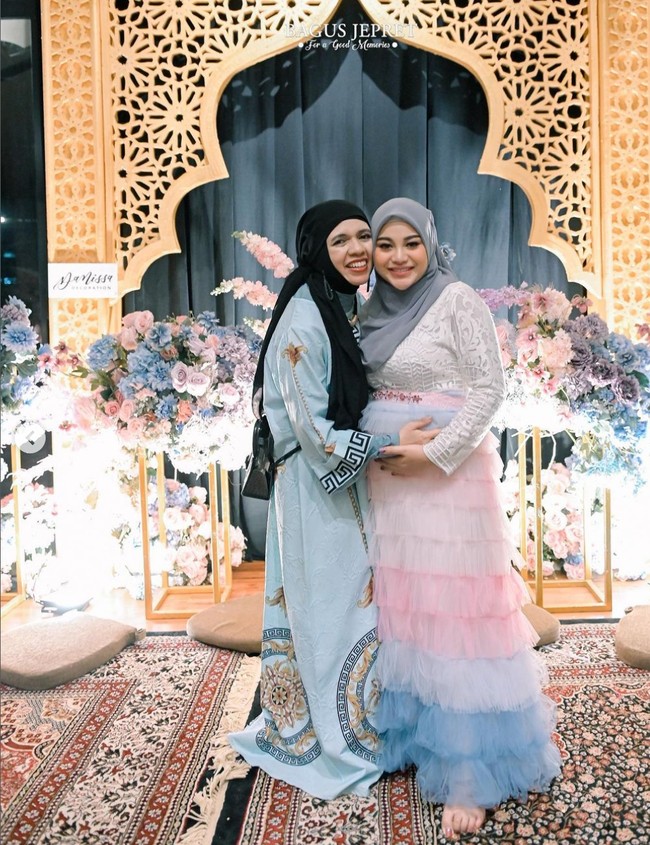 Lenggogeni Faruk, atau lebih dikenal dengan sapaan Ibu Geni, memakai gamis bermotif baroque dan tribal warna teal. Dia memadukan gamisnya dengan jilbab hitam. Foto: Instagram