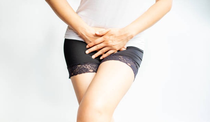 Young woman hand holding pressing her above crotch. Period Pain or vaginal or urinary infection woman health Problem. Health Issues Concept.