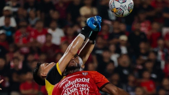 Kiper PSM Makassar Reza Arya Pratama berduel dengan striker Bali United, Privat Mbarga dalam leg 1 kualifikasi playoff Liga Champions Asia.