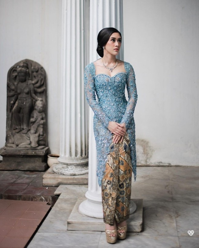 Kusuma yang berprofesi sebagai dokter kecantikan mengenakan kebaya biru penuh hiasan payet dan bordir rancangan Anji Asmara. Ia memadukannya dengan kain batik wiron. Foto: Instagram/@kusumaputeri