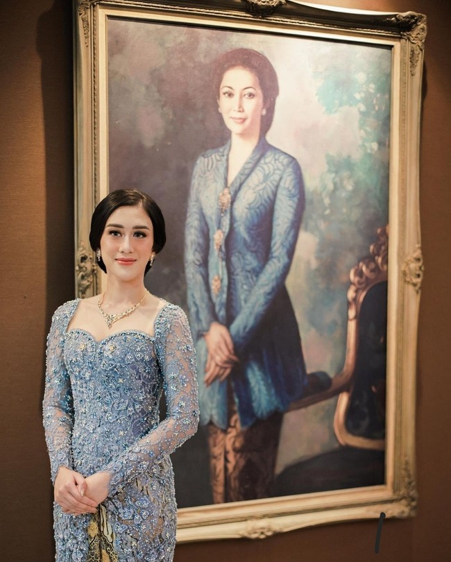 Pose di depan lukisan Mooryati Soedibyo, Kusuma Sri Whisnu Puteri tampak mewarisi kecantikan sang nenek. Kebaya dan kain yang dikenakan pun berwarna senada. Foto: Instagram/@kusumaputeri