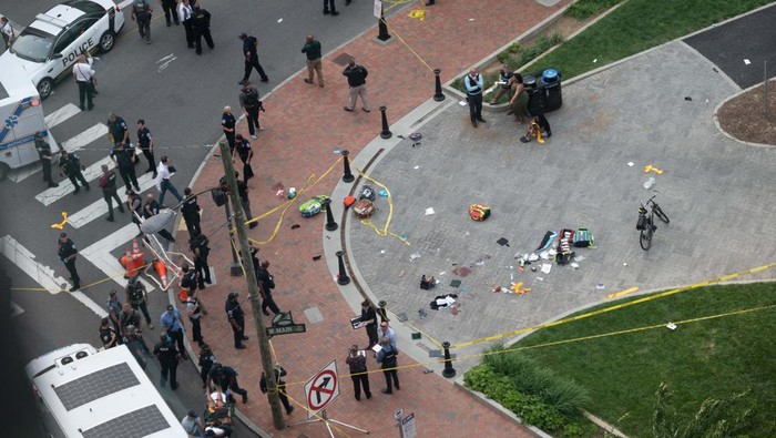Penembakan di Acara Kelulusan SMA, 2 Orang Tewas Law enforcement officers investigate at the scene after a gunman opened fire in a park as high school graduates and their families emerged from a theater where commencement exercises had just concluded, in Richmond, Virginia, U.S. June 6, 2023 in this picture obtained from social media. Clark Frierson/Instagram @by.esign/via REUTERS THIS IMAGE HAS BEEN SUPPLIED BY A THIRD PARTY. MANDATORY CREDIT.