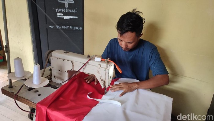 Perajin bendera di Dusun Ranjirata Desa Cimari Ciamis tengah menjahit bendahara.
