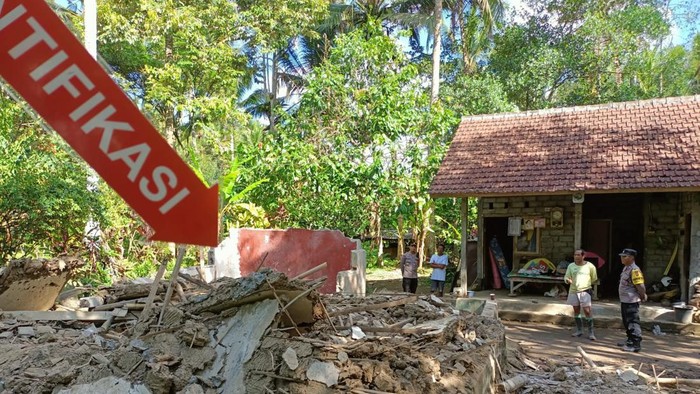 Petugas Polsek Penebel melakukan identifikasi pada bangunan rumah milik I Gusti Putu Nadi yang hancur tertimpa batang pohon kelapa, Rabu (7/6/2023). (chairul amri simabur/detikBali)
