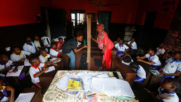 Sekolah di Nigeria Ini, Bayarnya Pakai Sampah Elizabeth Samuel, 37, a parent of a student of My Dream Stead, a low-cost school that accepts recyclable wastes as payment, carries sacks of plastic waste for submission in Ajegunle, Lagos, Nigeria May 19, 2023. REUTERS/Temilade Adelaja