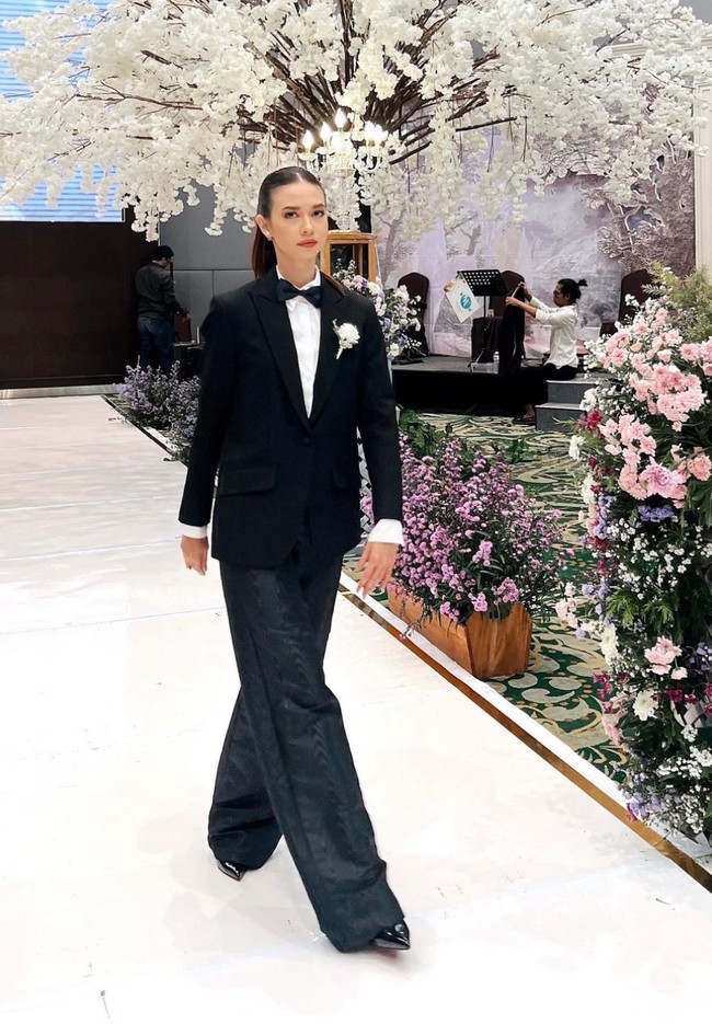 Yuki Kato menampilkan gaya androgini, memakai jas hitam yang dipadukan celana berpotongan lebar warna senada dan dasi kupu-kupu. Foto: Instagram/@yukikt, Askar Photography