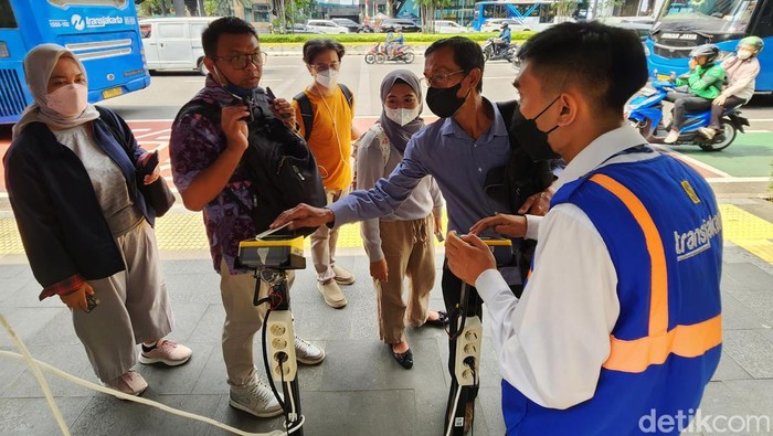 Halte Darurat TransJakarta Saat Revitalisasi Penumpang ngetap kartu pembayaran non cash Bus TransJakarta di Karet 2 Jakarta, Rabu (7/6/2023). PT Transportasi Jakarta (TransJakarta) menyediakan fasilitas Layanan TransJakarta sebagai pengganti halte yang sedang dalam proses revitalisasi. Layanan TransJakarta itu tampak terlihat sederhana dengan adanya banner sebagai penunjuk informasi dengan mesin tap. Selain itu, pembatas halte hanya diberi garis pembatas kecil.