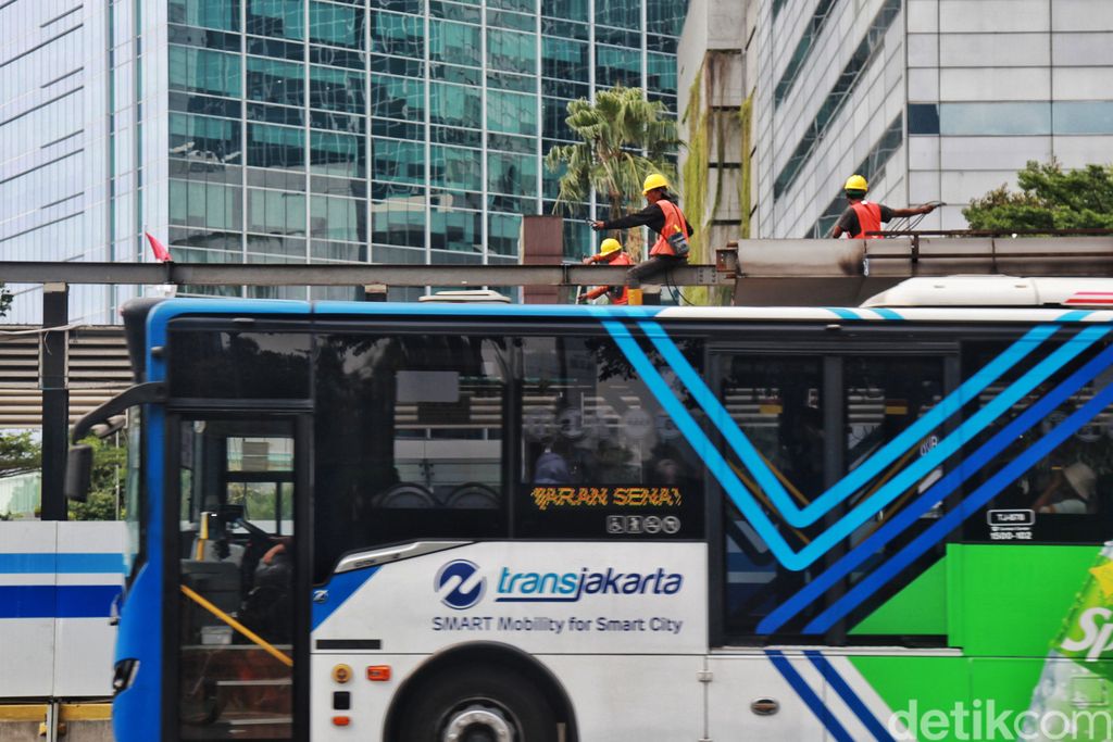 Penumpang ngetap kartu pembayaran non cash Bus TransJakarta di Karet 2 Jakarta, Rabu (7/6/2023). PT Transportasi Jakarta (TransJakarta) menyediakan fasilitas Layanan TransJakarta sebagai pengganti halte yang sedang dalam proses revitalisasi. Layanan TransJakarta itu tampak terlihat sederhana dengan adanya banner sebagai penunjuk informasi dengan mesin tap. Selain itu, pembatas halte hanya diberi garis pembatas kecil.
