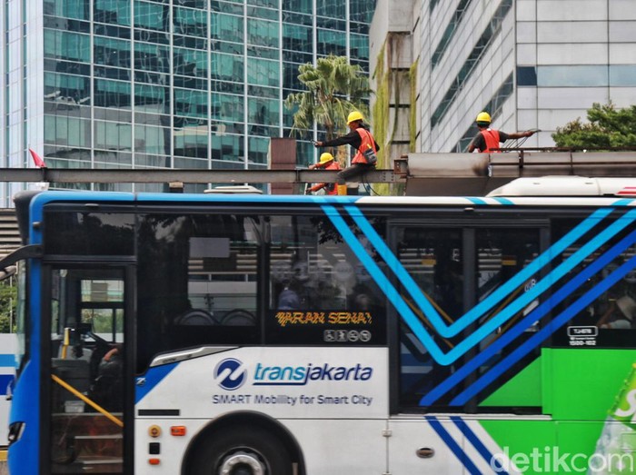 Penumpang ngetap kartu pembayaran non cash Bus TransJakarta di Karet 2 Jakarta, Rabu (7/6/2023). PT Transportasi Jakarta (TransJakarta) menyediakan fasilitas Layanan TransJakarta sebagai pengganti halte yang sedang dalam proses revitalisasi. Layanan TransJakarta itu tampak terlihat sederhana dengan adanya banner sebagai penunjuk informasi dengan mesin tap. Selain itu, pembatas halte hanya diberi garis pembatas kecil.