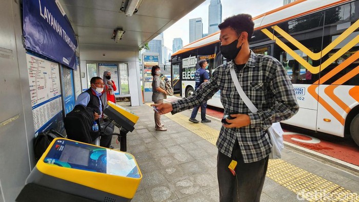 Halte Darurat TransJakarta Saat Revitalisasi Penumpang ngetap kartu pembayaran non cash Bus TransJakarta di Karet 2 Jakarta, Rabu (7/6/2023). PT Transportasi Jakarta (TransJakarta) menyediakan fasilitas Layanan TransJakarta sebagai pengganti halte yang sedang dalam proses revitalisasi. Layanan TransJakarta itu tampak terlihat sederhana dengan adanya banner sebagai penunjuk informasi dengan mesin tap. Selain itu, pembatas halte hanya diberi garis pembatas kecil.