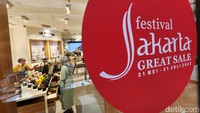 Pengunjung pusat perbelanjaan melintas di depan papan diskon Festival Jakarta Great Sale di salah satu mal di Jakarta Selatan, Kamis (8/6/2023).