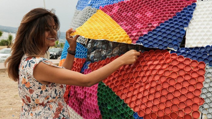 Kampanye Lingkungan, Aktivis Bikin Penyu Warna-warni dari Botol Plastik Graphic designer Sahar Ghouche walks with her daughter Christy Maria next to a turtle made from plastic caps and bottles in Amchit, Lebanon June 1, 2023. REUTERS/Issam Abdallah