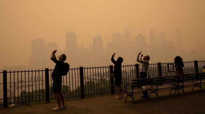 Langit New York Berubah Oranye Gegara Asap Kebakaran Hutan BROOKLYN, NEW YORK - JUNE 7: In the middle of the afternoon, smoke from Canadian forest fires blankets the skyline of New York City, June 7, 2023, as seen from Brooklyn, New York. The city issued an air quality advisory, urging all citizens to stay indoors. (Photo by Andrew Lichtenstein/Corbis via Getty Images)
