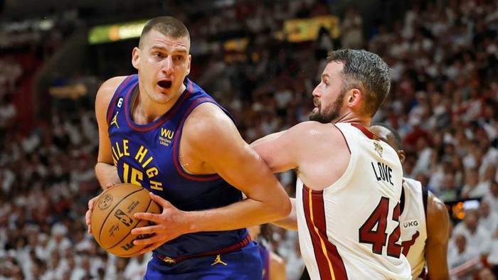 The Denver Nuggets Nikola Jokic (15) drives against the Miami Heats Kevin Love (42) during the first half of Game 3 of the NBA Finals at the Kaseya Center on Wednesday, June 7, 2023, in Miami. (Al Diaz/Miami Herald/Tribune News Service via Getty Images)