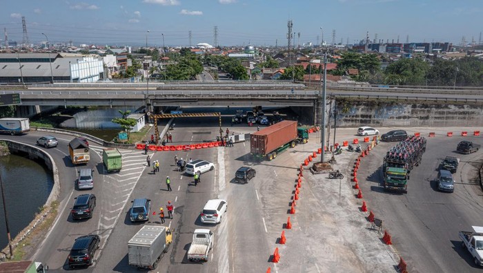 Potret Rekayasa Lalin Proyek Peninggian Jalan dan Jembatan Tol Kaligawe Semarang Foto udara suasana simulasi rekayasa lalu lintas untuk proyek peninggian jalan dan jembatan Tol Kaligawe di jalur Pantura, Semarang, Jawa Tengah, Kamis (8/6/2023). Simulasi rekayasa lalu lintas yang dilakukan Satlantas Polrestabes Semarang pada Kamis (8/6) hingga Sabtu (10/6) di sekitar titik proyek jalan dan jembatan yang akan terhubung ke jalan Tol Semarang-Demak Seksi 1A itu sebagai upaya mitigasi penguraian arus lalu lintas di jalur pantura saat pengerjaan proyek tersebut yang direncanakan akan dimulai pada Minggu (11/6). ANTARA FOTO/Aji Styawan/foc.