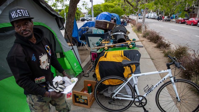 LOS ANGELES, CA - JUNE 07: Brittany, 31, packs her tent before clean-up by Los Angeles City sanitation of an encampment along 200 block of S. Venice Blvd., Los Angeles, CA. (Irfan Khan / Los Angeles Times via Getty Images)