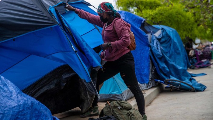 LOS ANGELES, CA - JUNE 07: Brittany, 31, packs her tent before clean-up by Los Angeles City sanitation of an encampment along 200 block of S. Venice Blvd., Los Angeles, CA. (Irfan Khan / Los Angeles Times via Getty Images)