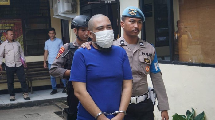 Petugas kepolisian mengamankan tersangka yang menganiaya anak kandungnya sendiri di Mapolres Purbalingga, Jumat (9/6/2023).