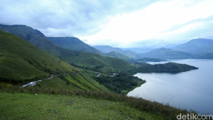 Pengunjung berfoto di Bukit Holbung, Samosir, Sumatera Utara, Rabu (15/2/2023). Keindahan bukit ini dapat dinikmati wisatawan hanya dengan menaiki anak tangga.