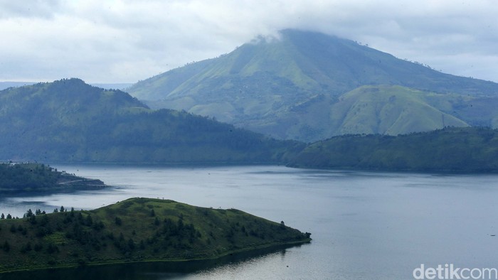 Pengunjung berfoto di Bukit Holbung, Samosir, Sumatera Utara, Rabu (15/2/2023). Keindahan bukit ini dapat dinikmati wisatawan hanya dengan menaiki anak tangga.