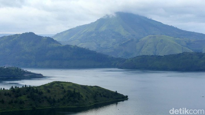 Pengunjung berfoto di Bukit Holbung, Samosir, Sumatera Utara, Rabu (15/2/2023). Keindahan bukit ini dapat dinikmati wisatawan hanya dengan menaiki anak tangga.